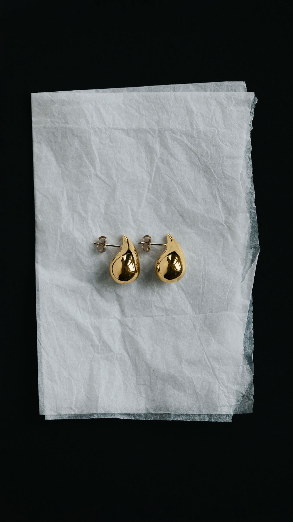 Large teardrop stud earrings in 9ct yellow gold, worn