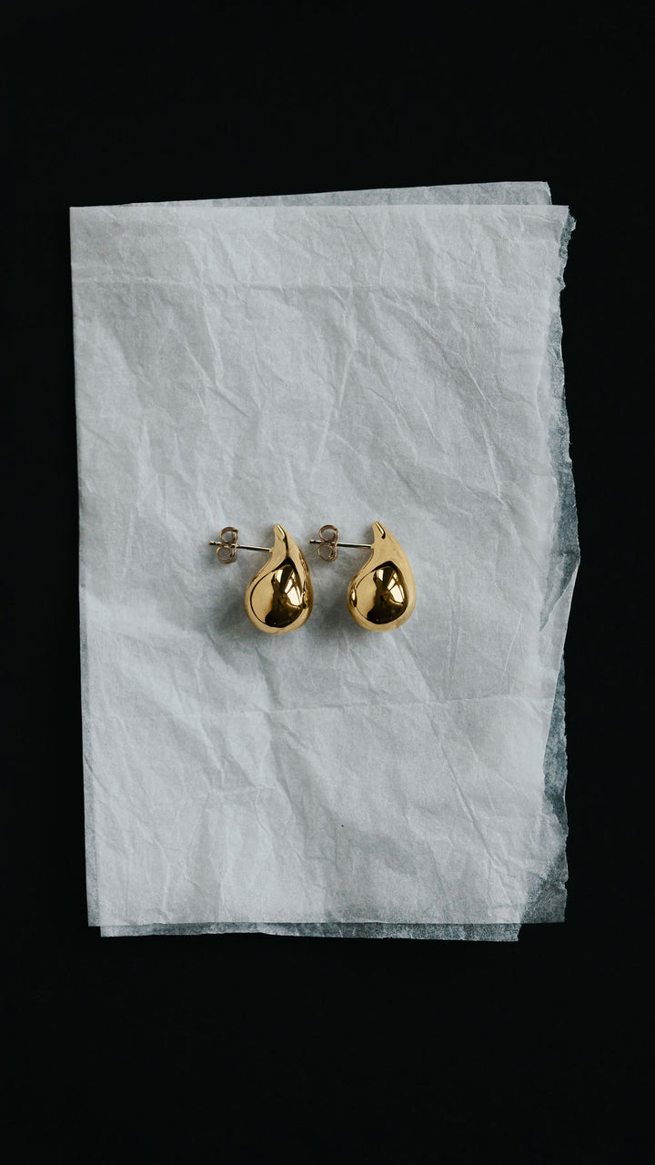 Large teardrop stud earrings in 9ct yellow gold, worn