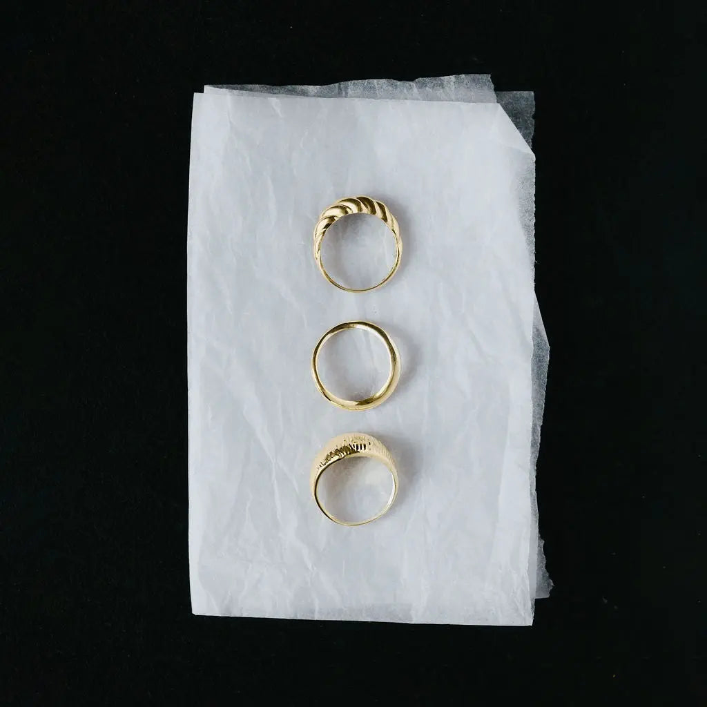 Solid 9ct yellow gold twisted rope ring shown alongside other gold rings