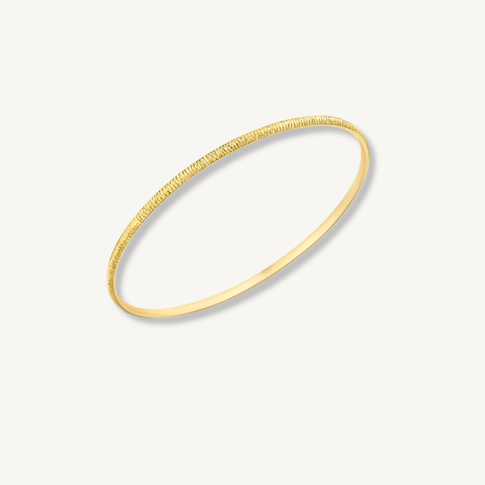 Gold bracelet on a light gray background