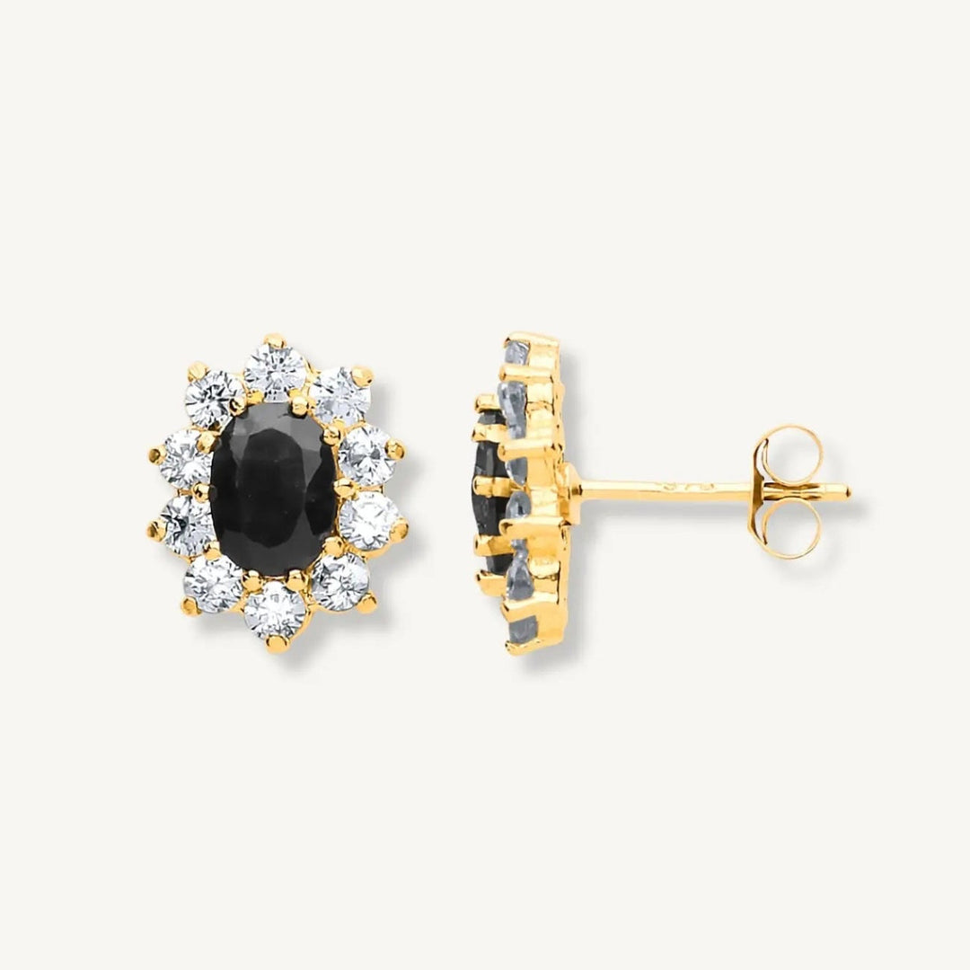 Gold earrings with black gemstones on a white background