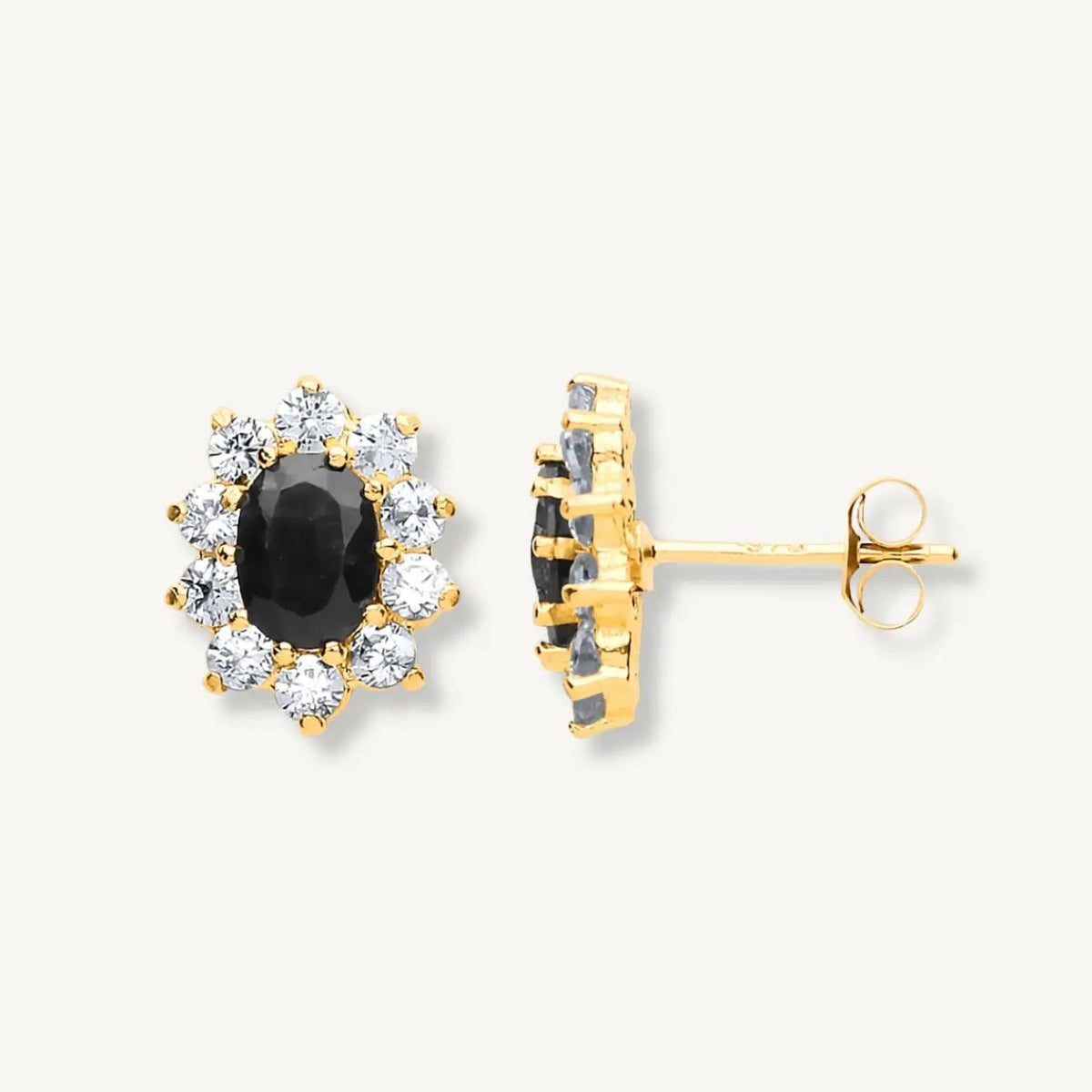 Gold earrings with black gemstones on a white background