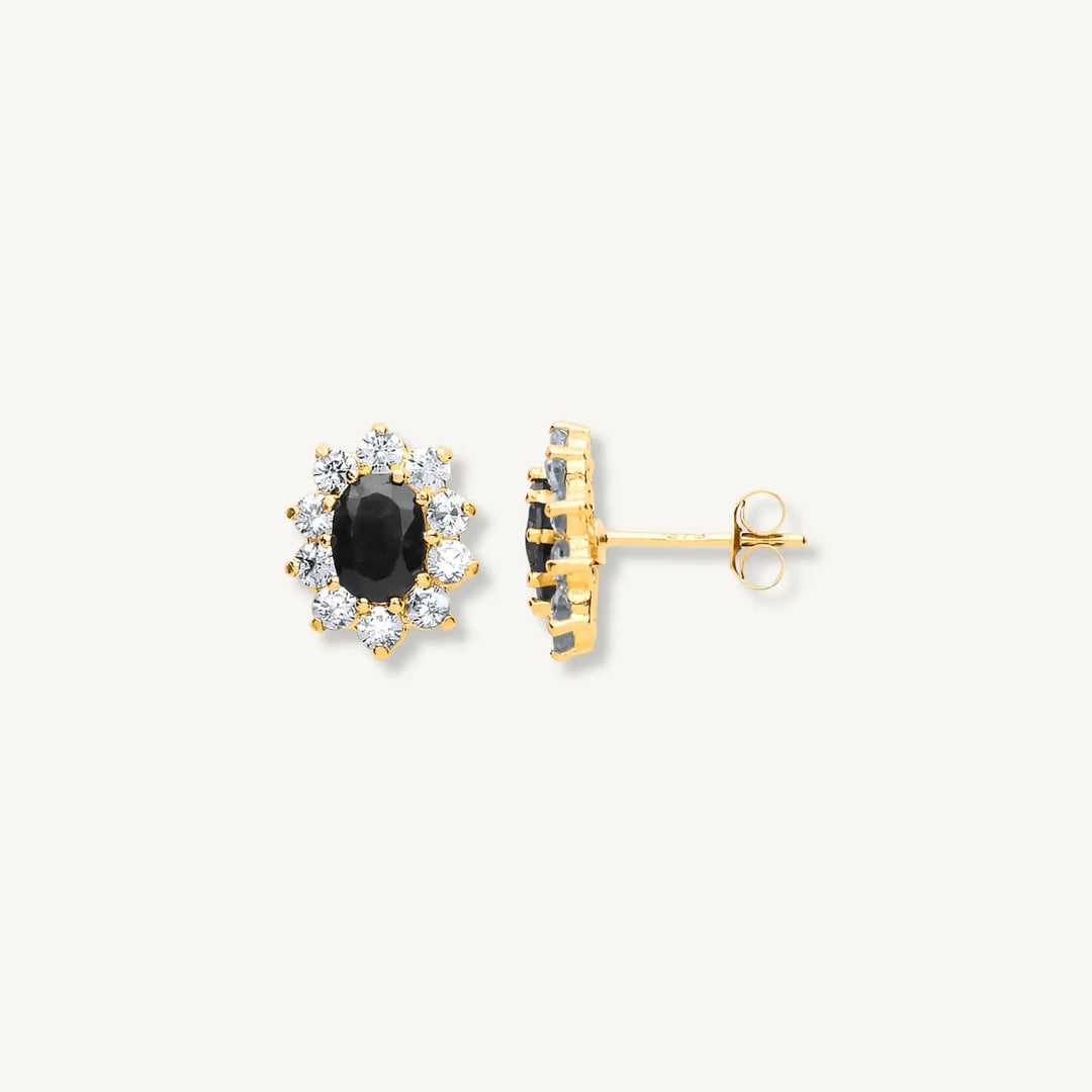 Gold earrings with black gemstones on a white background