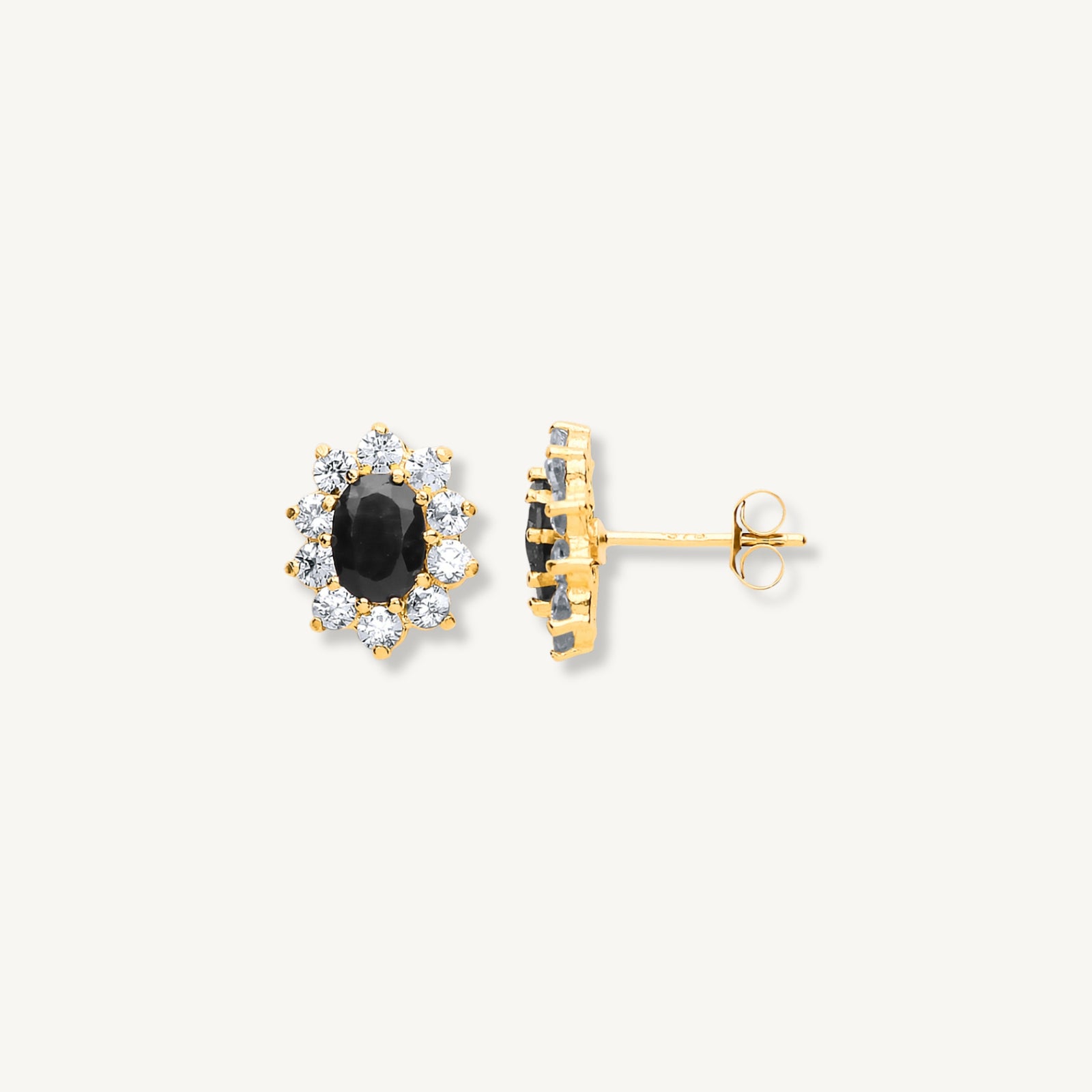 Gold earrings with black gemstones on a white background