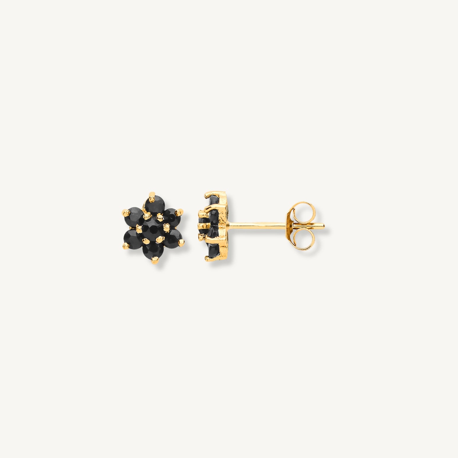 Gold earrings with black gemstones on a white background