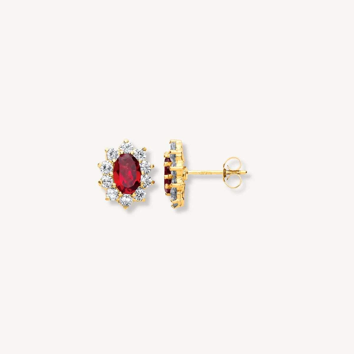 Gold earrings with a central red gemstone on a white background