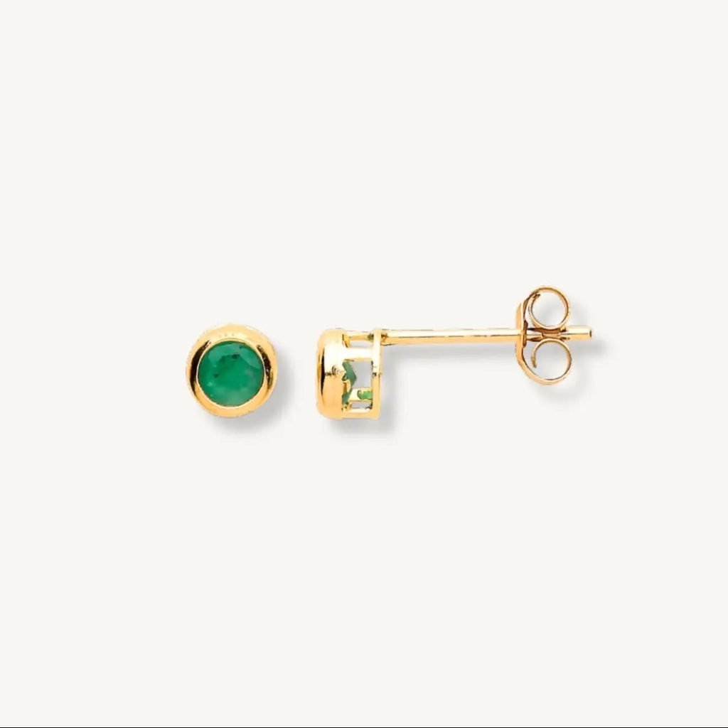 Gold earrings with green gemstones on a white background