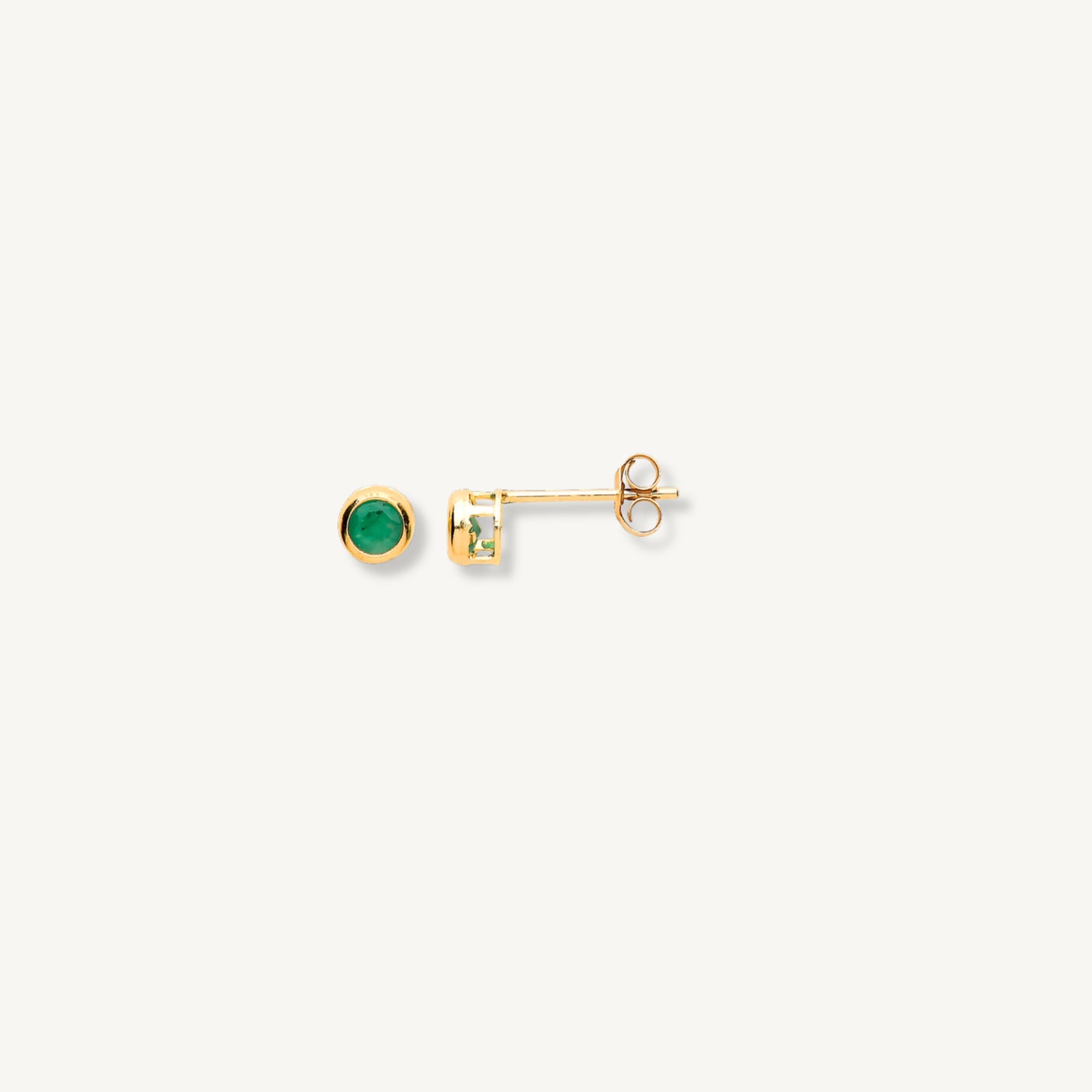 Gold earrings with green gemstones on a white background