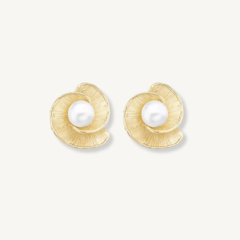 Gold earrings with pearl centers on a white background