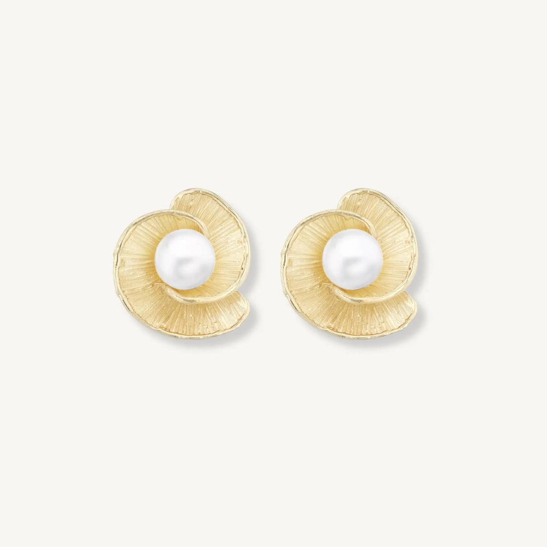 Gold earrings with pearl centers on a white background